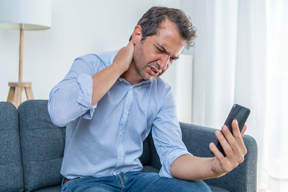 Man holding phone with bad posture.
