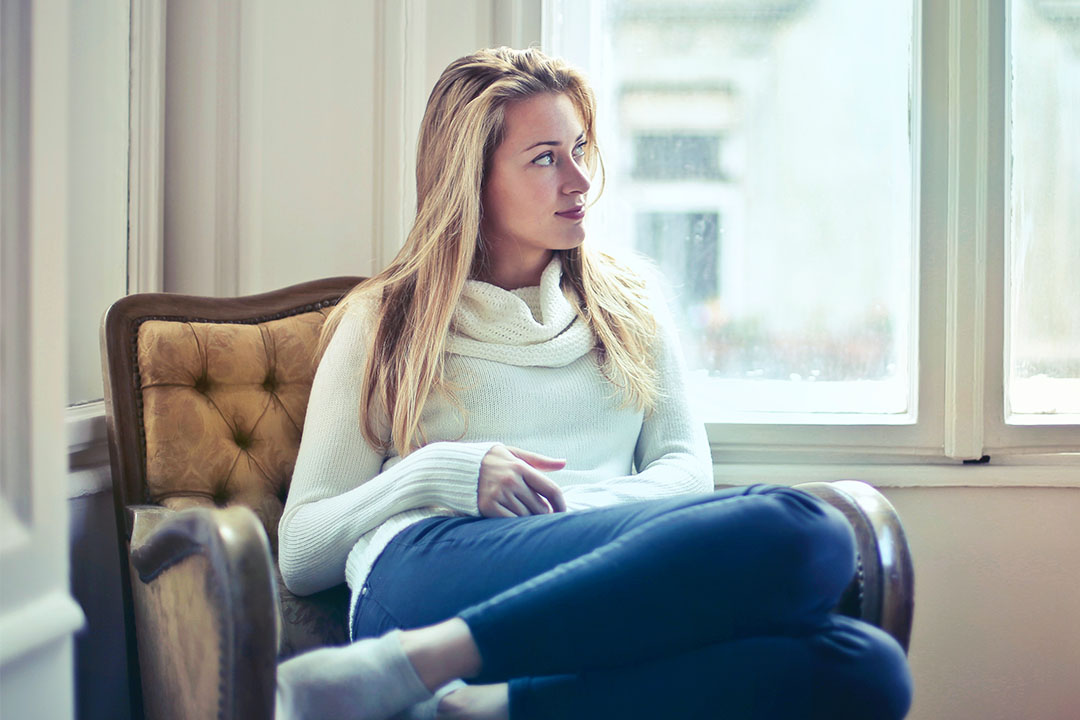 Woman sitting on couch resting.