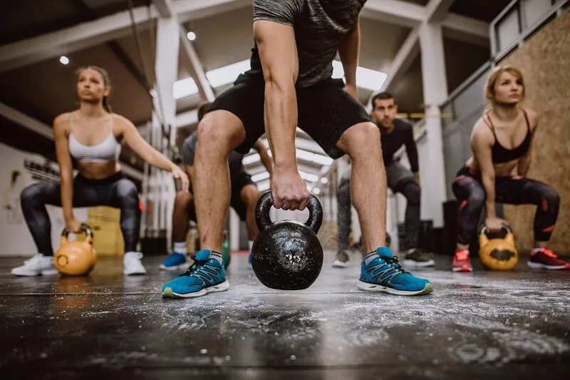 Crossfit athlete performing weightlifting exercises with weights.