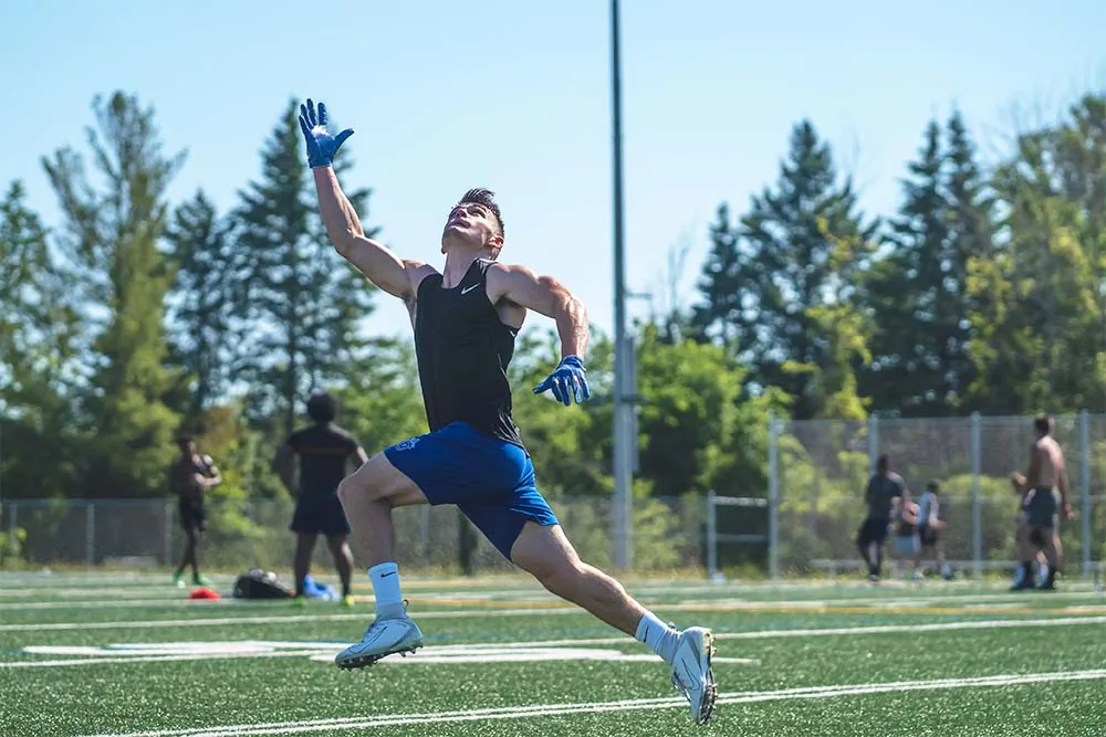 Young football player running to catch the ball.