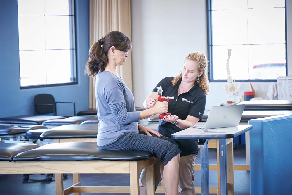 Physical therapist working on a patients hand.