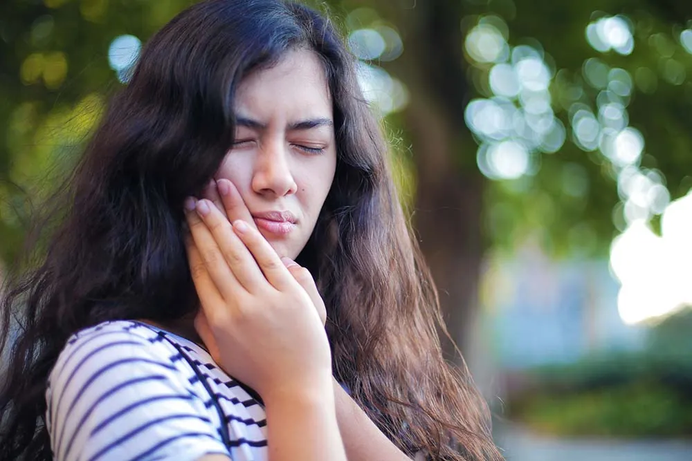 Woman suffering from jaw pain.