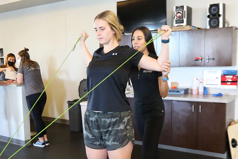PT, Alicia helping patient strengthen arms.