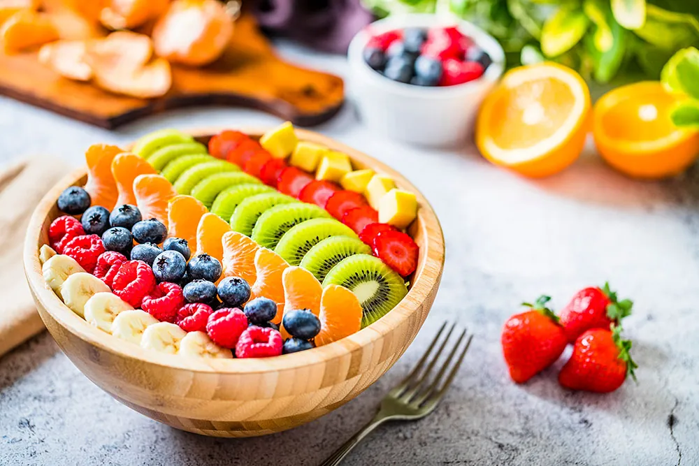 Bowl of fresh fruit including berries, orange and mango.