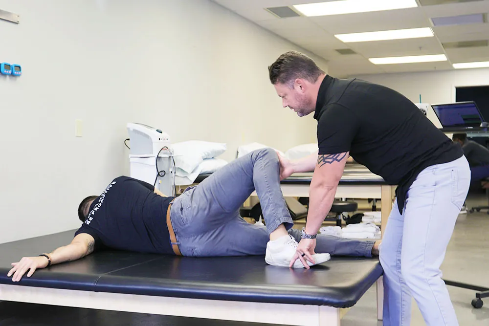 PT, Scott helping patient with his form while strecthing.