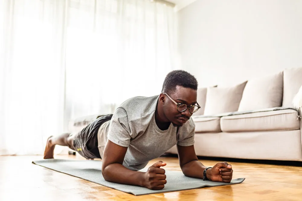 Man does a plank on his yoga mat.