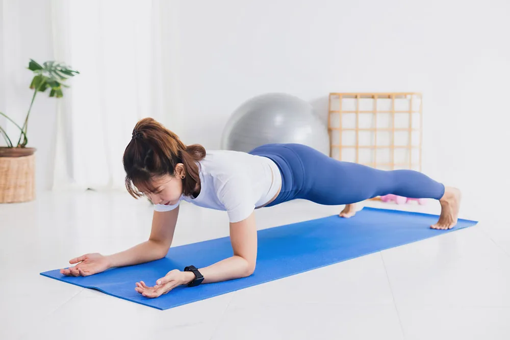 Young woman is performing a plank exercise.