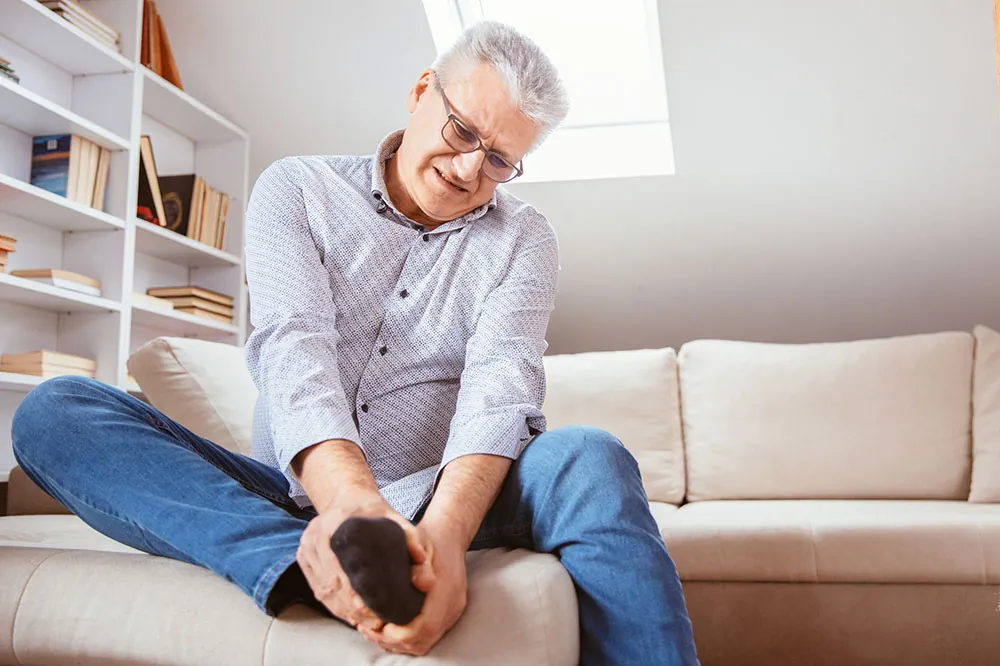 Senior man suffering plantar fasciitis pain.